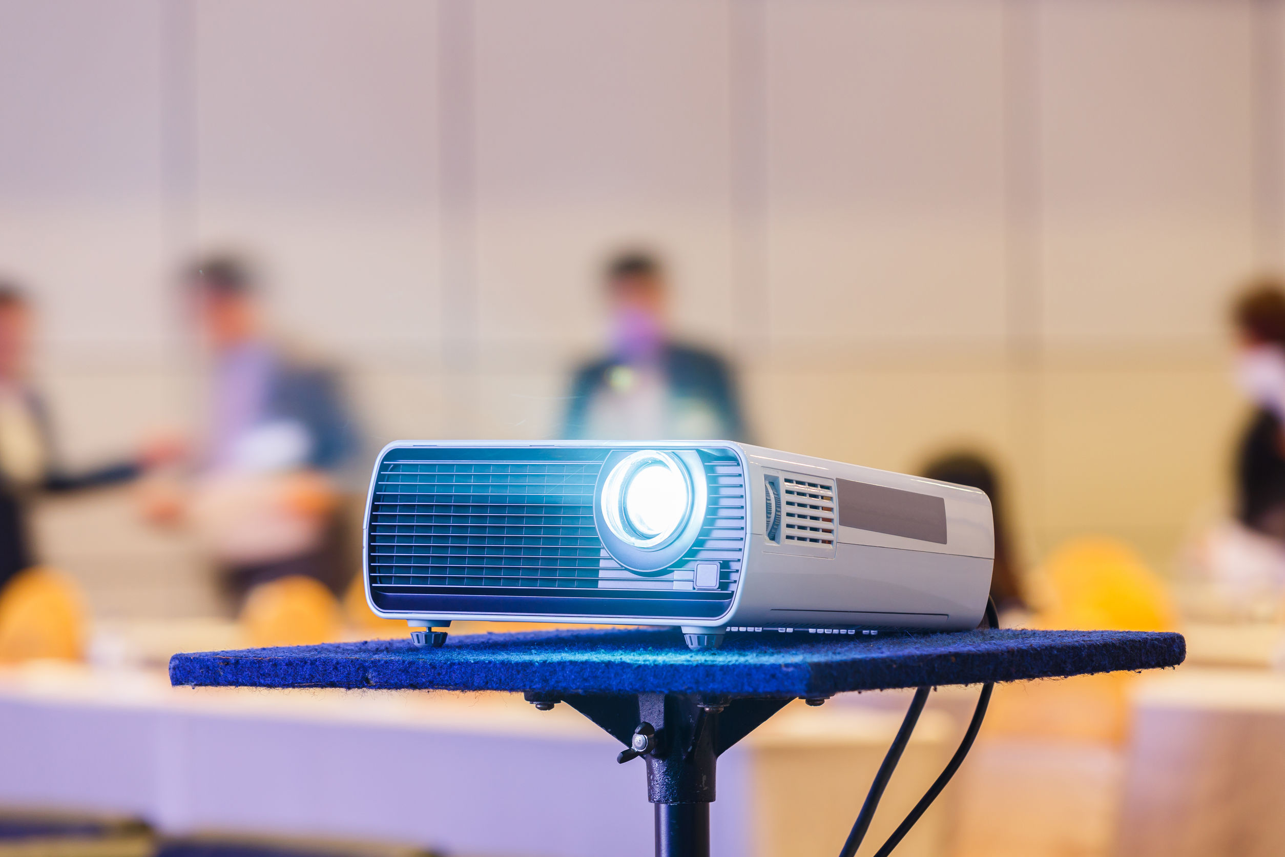 56460728 – close up projector in conference room with blurry people background
